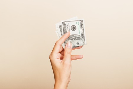 female hand holding dollars billsの写真素材