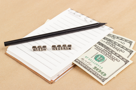 The new work - paper money with notepad and pencil on the paper backgroundの写真素材