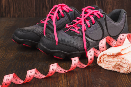 Pair of sneakers and pink towel, wooden backgroundの写真素材
