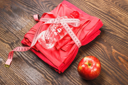Sport clothing, measuring tape and apple, wooden backgroundの写真素材