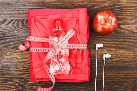 Sport clothing, measuring tape and bottle, wooden backgroundの写真素材