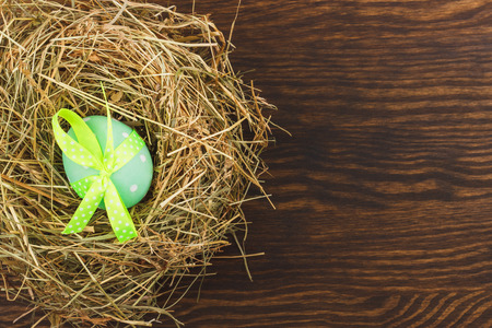 Green chicken egg in the nest, wooden backgroundの写真素材