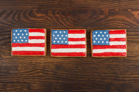 Flag shaped cookies with American patriotic colors on the wooden background