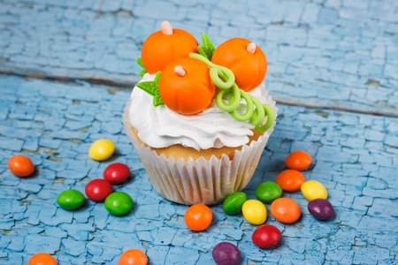 Halloween cupcake with decorations: orange pumpkins made from confectionery mastic, soft focus backgroundの写真素材