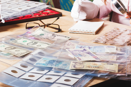 Different collector's coins and banknotes on the table, wooden backgroundの写真素材
