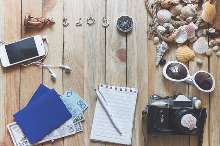 Striped espadrilles, money, passports and marine decorations on the wooden background, top viewの写真素材