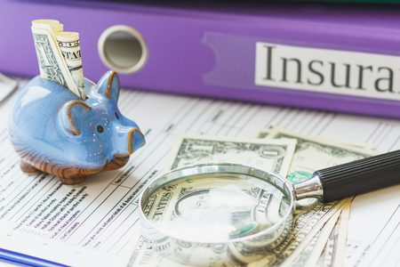 Insurance form, piggy bank with dollars and magnifying glassの写真素材