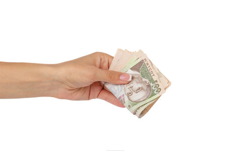 Woman's hand holds banknotes of five hundred hryvnias, isolated on white