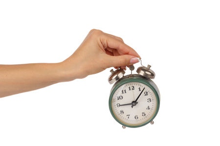 Green alarm clock in the woman's hand, isolated on whiteの写真素材