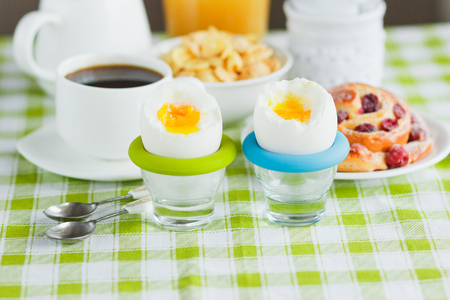 Soft boiled chicken egg, coffee, muesli and orange juice, soft focus backgroundの写真素材
