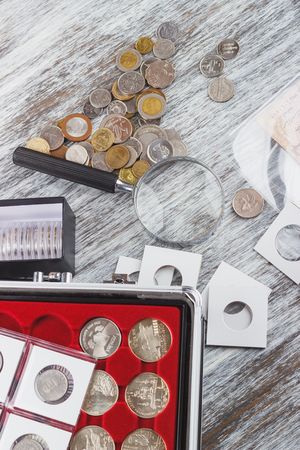 Different collector coins and a magnifying glass, top viewの写真素材