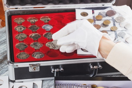 Hand in a glove with a silver coin, soft focus backgroundの写真素材