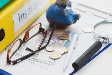 Clean insurance blank, Polish zloty, magnifying glass, glasses and piggy bank, soft focus background