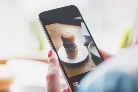 French colored macarons on the plate and a cup of coffee, soft focus backgroundの写真素材