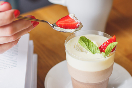 Coffee dessert with strawberry and leaves of mint, soft focus backgroundの写真素材