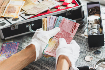Hands in the white gloves hold different banknotes, top viewの写真素材