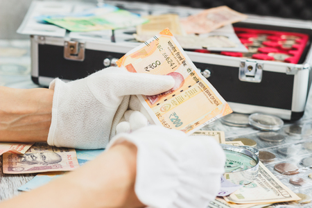 Hands in white gloves hold rupiah, numismatics concept, blurred backgroundの写真素材