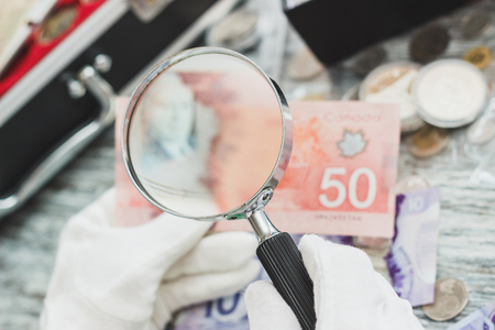 Hands in white gloves, different Canadian dollars, numismatics concept, blurred backgroundの写真素材