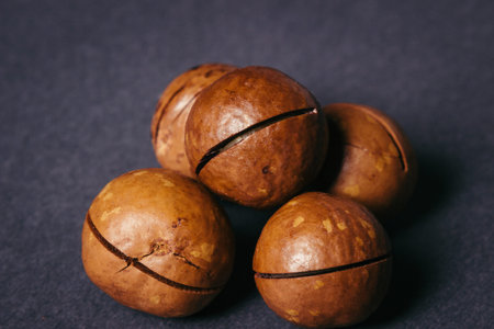 Healthy Food - Several Macadamia Nuts on a Black Background