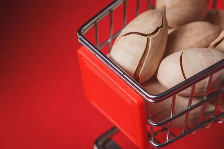 Background: pecan on a red background in a miniature trolley, foodの写真素材