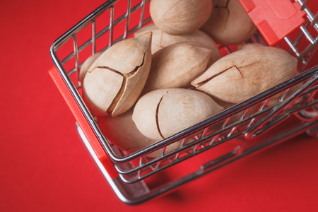Background: pecan on a red background in a miniature trolley, food
