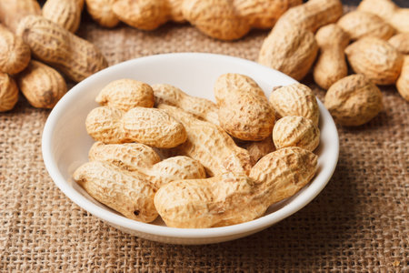 Background from golden peanuts in the shells, soft focus background