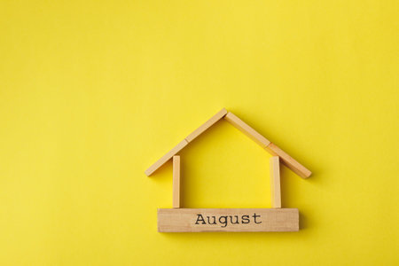 house shaped wooden logs on the yellow background, top view