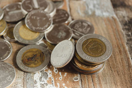 Gold, silver coins and decorative house, wooden backgroundの写真素材