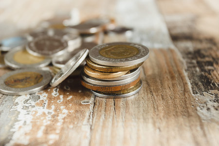 Gold, silver coins and decorative house, wooden background