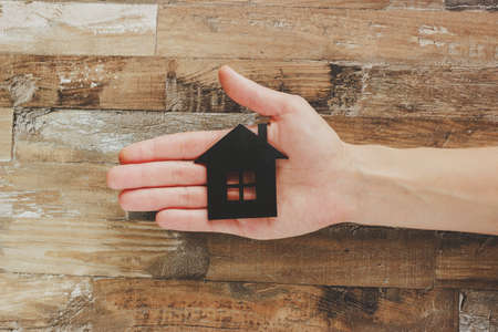Gold, silver coins and decorative house, wooden backgroundの写真素材