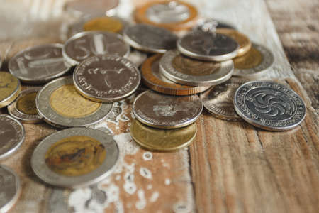 Gold, silver coins and decorative house, wooden backgroundの写真素材