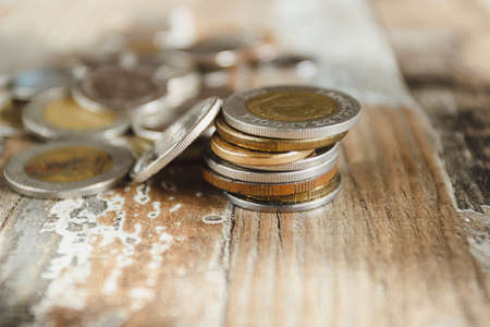 Gold, silver coins and decorative house, wooden backgroundの写真素材