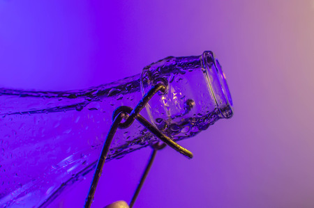 Bottle with droplets with color lights in backgroundの写真素材