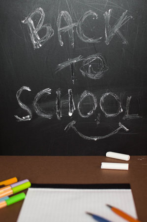 School supplies on blackboard background - back to school