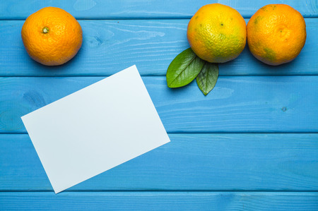 Fresh tangerines on a vibrant blue wooden table background, border copy spaceの写真素材