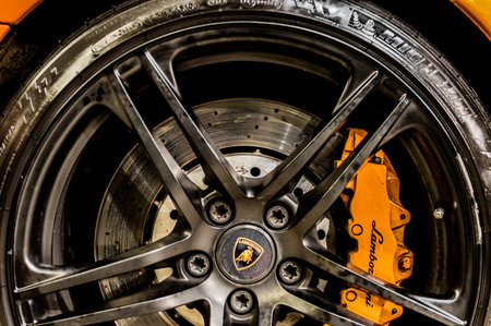 Close up of a car's rim, wheel and breaks with Lamborghini emblem.