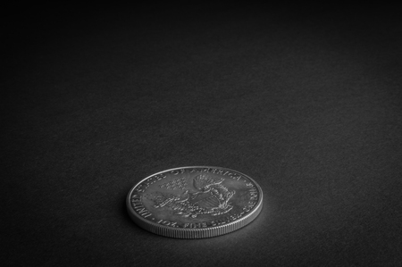 Silver one dollar coin standing on black surface - business concept, isolated.の写真素材