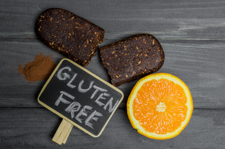 Bio gluten free protein bar with ingredients and copyspace sign on wooden table.の写真素材