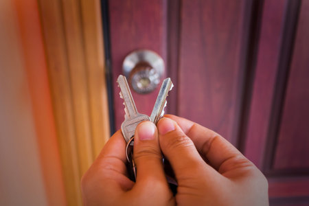 Hand hold two key with blurred door background,choose the right one concept