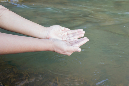 Two hand ladle natural pure water in the riverの写真素材