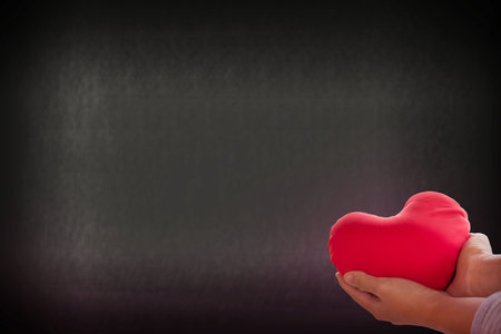 Romantic lovely valentine concept with hand gently raise up red heart on soft bokeh background