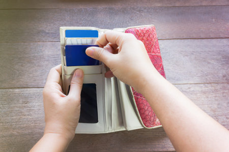Hands pull credit card out of wallet