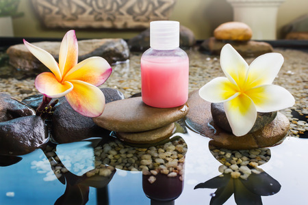 Mini set of bubble bath and shower gel decorated in zen style with pebble rock and flower with relaxing moodの写真素材