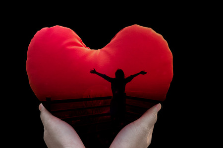 Isolated freedom silhouette women in red heart on black background in hands (With clipping path)の写真素材