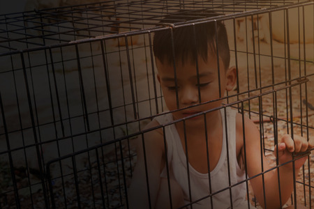Boy or kid imprison in cage, kidnap or missing child conceptの写真素材