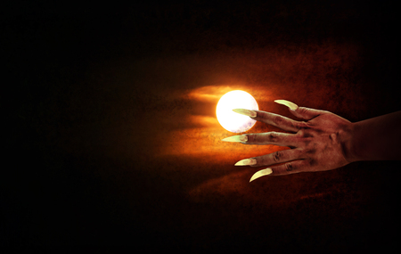 Human hand with long fingernail or devil hand on full moon night with grunge covered for halloween background, horrendous or frightful hand at moon nightの写真素材