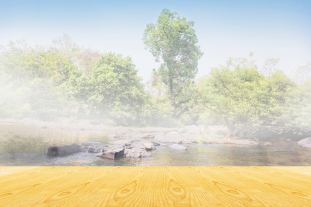 Blank area or space table top on waterfall or river view in forest and puffy clouds sky backgroundの写真素材