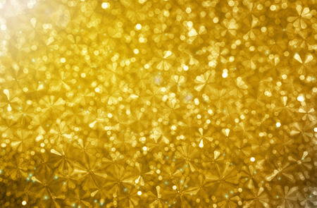Abstract small flower shape in glow golden bokeh light background, dreamy sparkle glittery wonderful and luxury backgroundの写真素材