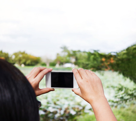 Asian lady take picture from mobile or smartphone with blank space areaの写真素材