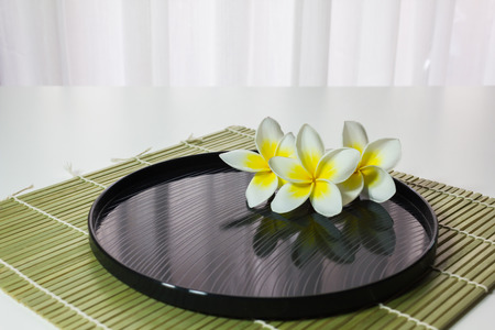 Flowers group plumeria or frangipani on water with reflection,white and yellow flowers and shadow on water in meditation soft moodの写真素材